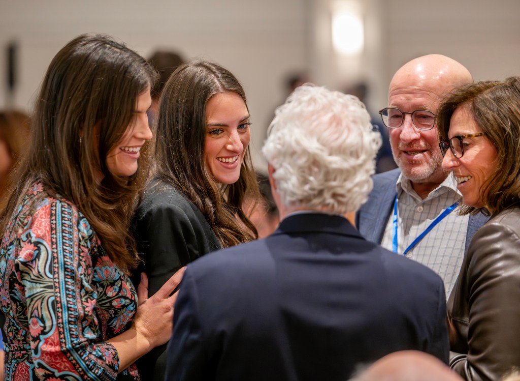 A group of five people engaged in a lively conversation, smiling and laughing during the Jewish Foundation of Memphis' 30th Anniversary event.